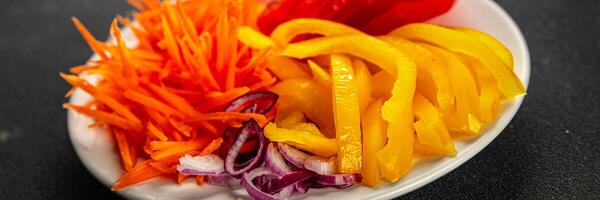 salad fresh vegetables cut into a plate tomato, carrot, pepper, onion juicy fresh gourmet food background on the table rustic food top view copy space keto and paleo diet Vegetarian and vegan photo