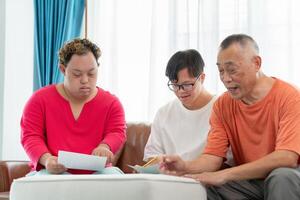Senior man and grandchild practice math skill, interactive math game, Grandfather supervising grandchild sitting at sofa doing homework photo