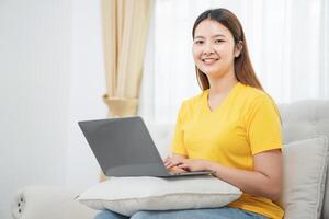 Asian woman wear casual sitting on couch using computer laptop at home photo