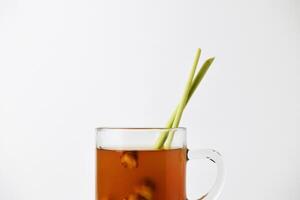 Hot red ginger drink in glass on wooden coaster and isolated white background photo