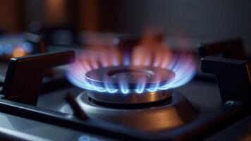 Close-up of a lit gas stove burner with blue flame, in a kitchen. Focus on the burner with blurred background. Concept of cooking, energy photo