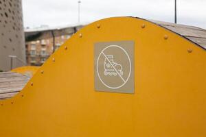 Sign with crossed out roller on decorative structure for people to sit on. Do not use structure in the park as ramp, roller skating safety without tricks photo