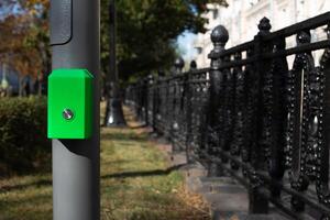 Button for changing the traffic light mode at pedestrian crossing. Button for pedestrians on pole to change traffic light signal to cross the road photo