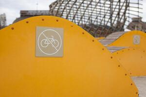 Sign prohibiting the use of decorative bench for bicycle stunts, safe movement in public park, prohibition of using bicycle photo