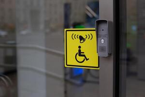 Button to call staff to assist person with disabilities at entrance. Accessible environment for people in wheelchair, entrance to modern building with conditions for the disabled people photo
