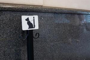 Tie the dog with leash to post to wait for owner outside. Pole to secure pet from escaping in public place, safe condition for waiting for dog in city photo