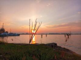 A sunset over the water with a boat in the background photo