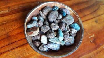 A bowl filled with rocks on a wooden table photo