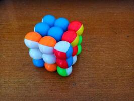 A colorful cube with many different colored balls on it photo