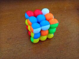 A colorful cube with many different colored balls on it photo