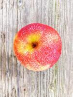 A red apple on a wooden surface photo