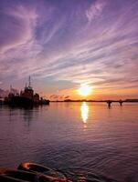 A boat is in the water at sunset photo