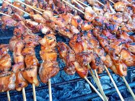 A grill with many skewers of meat on it photo
