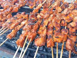 un parrilla con muchos brochetas de carne en eso foto