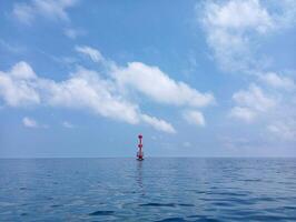 A red buoy in the middle of the ocean photo