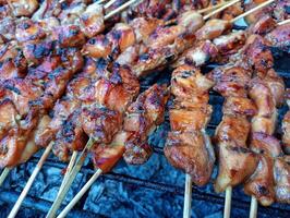 A grill with skewers of chicken on it photo