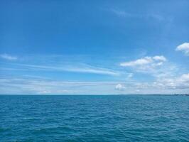 A blue sky with clouds over the ocean photo