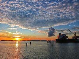 A large ship in the water at sunset photo