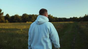 Young man travels alone walking on trail and enjoying on view of mountains field landscape at sunset, adventure traveling outdoor summer vacations enjoying video