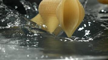 The pasta falls into the boiling water with splashes. Filmed on a high-speed camera at 1000 fps. High quality FullHD footage video