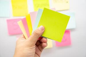 Hand holding blank colorful sticky note with Copy space. photo