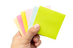 Hand holding blank colorful sticky note isolated on white background. Copy space photo