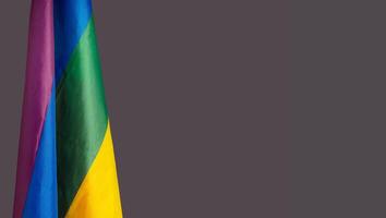Close-up of the rainbow flag or LGBT flag is on the left side on a gray background photo