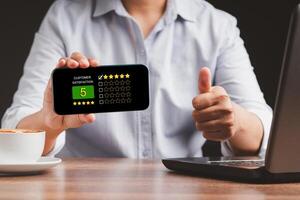 Man thumb up and showing a smartphone the five-star icon a rating of very impressed for service photo