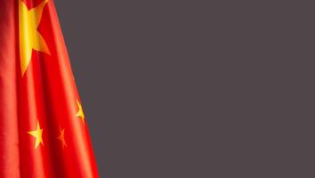 Close-up of the Chinese flag is on the left side on a gray background photo