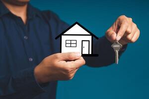 Mortgage and Investment property. Real estate agent with house model and keys photo