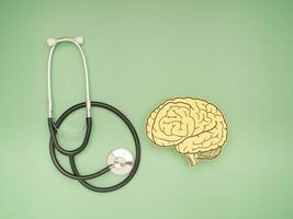 A stethoscope and brain shape made from paper over a green background photo