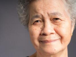 Close-up face of a smiling senior woman and looking at the camera photo