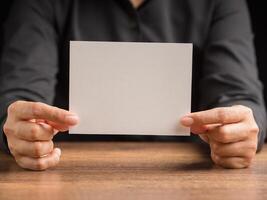 Hand holding of a blank paper while sitting in the office photo