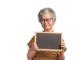 Elderly Asian woman holding a mini blackboard and looking at the camera with a smile while standing on a white background photo
