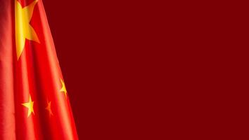 Close-up of the Chinese flag is on the left side on a red background photo