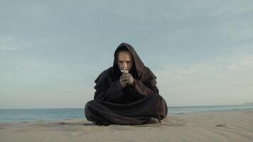 Monk Collected In Prayer Sitting On The Beach In The Evening photo