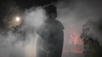 Monk With monster face walk in the night forest for Halloween photo