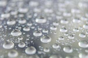 Side angle of clear raindrops on a transparent surface. Rain reflections theme photo