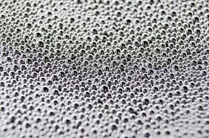Top view of soap bubbles forming patterns on a textured surface. Suitable for wallpaper background or design photo