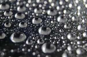 Side view of raindrops forming patterns on a smooth surface. Fresh rain texture photo