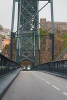 The Dom Luis I Bridge spans the Douro River in Porto, Portugal, with the historic Serra do Pilar Monastery in the background, showcasing a blend of modern and ancient architecture. photo