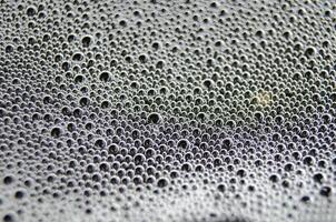 Soap bubbles forming patterns on a textured surface. Suitable for wallpaper background or design photo