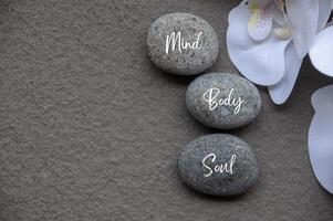 Top view of Mind, Body and Soul text on zen stones with additional customizable space for text photo