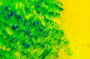 Top view of green watercolor brush stroke on yellow background photo