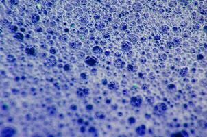 Top view of Macro shot of bubbles forming on a water surface with dark blue background photo