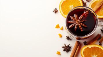 A glass of mulled wine with spices and oranges photo