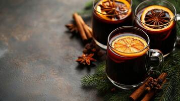 Two glasses of mulled wine with cinnamon and an orange photo