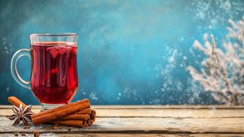 A glass of hot mulled wine with cinnamon and star anise on a wooden table photo