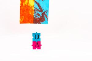Flag of Ukraine with blood and puzzles with letters of Ukraine on a white back. As the symble of struggle photo