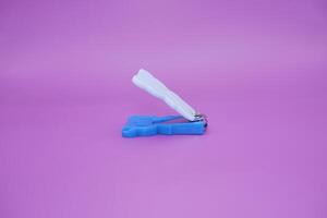 cute nail clippers isolated on purple background. cute nail clippers with blue and white color combination photo